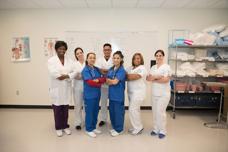 Diverse group of students and instructors smiling for a picture together.